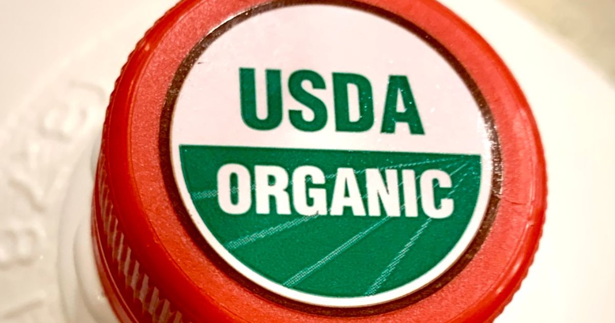 Close-up of a red bottle cap with a USDA Organic label.